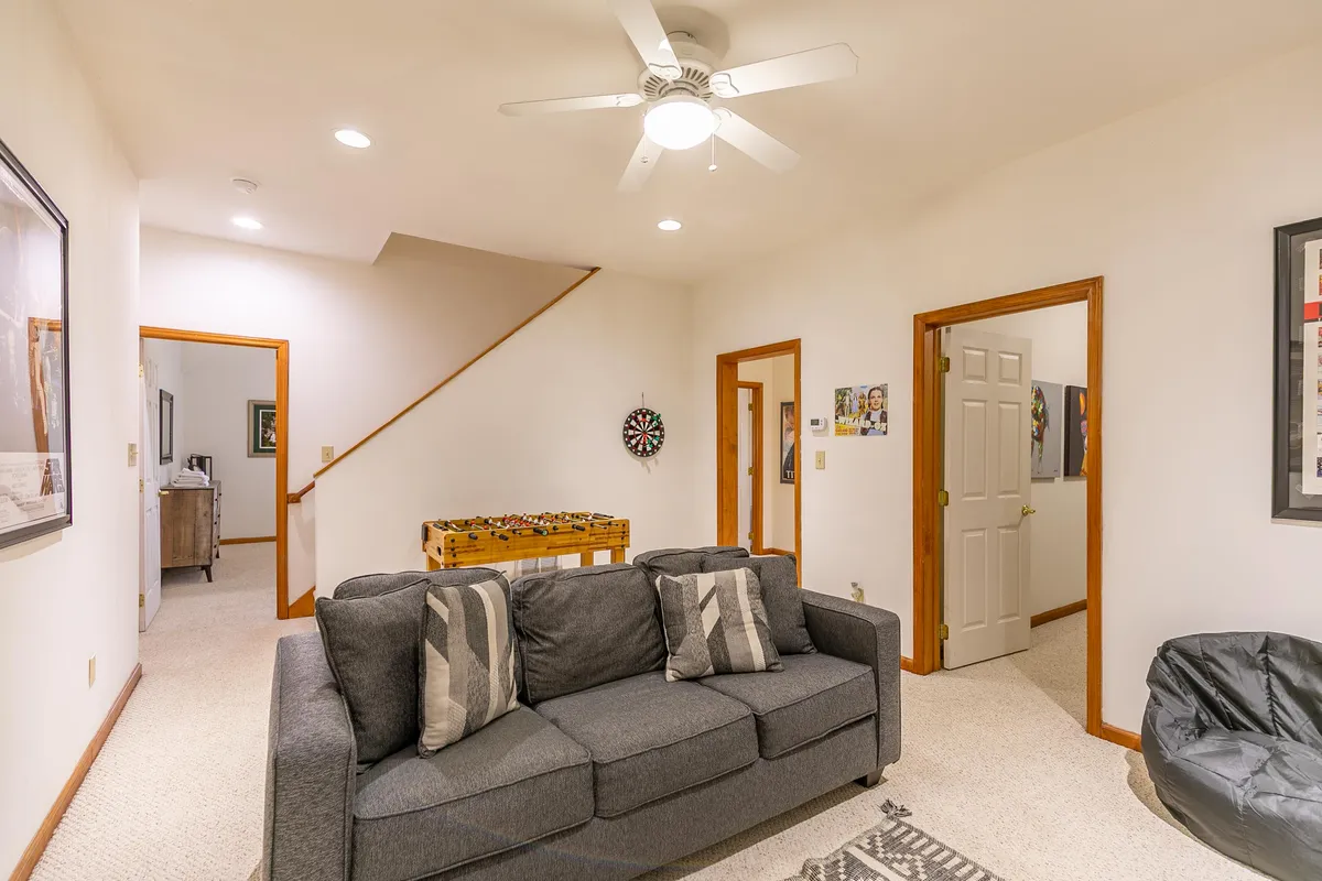 This photo highlights the game room's dartboard, foosball table, and a cozy sofa. The scene captures a space designed for friendly competition and relaxation, perfect for group gatherings or family fun.